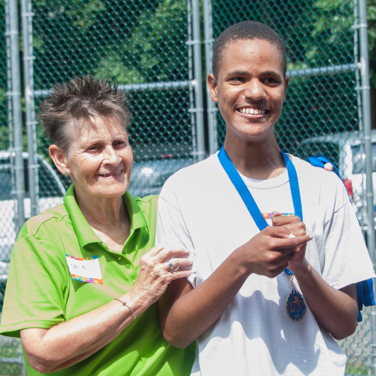 EDD Volunteer and Pickleball player smiles after receiving his medal