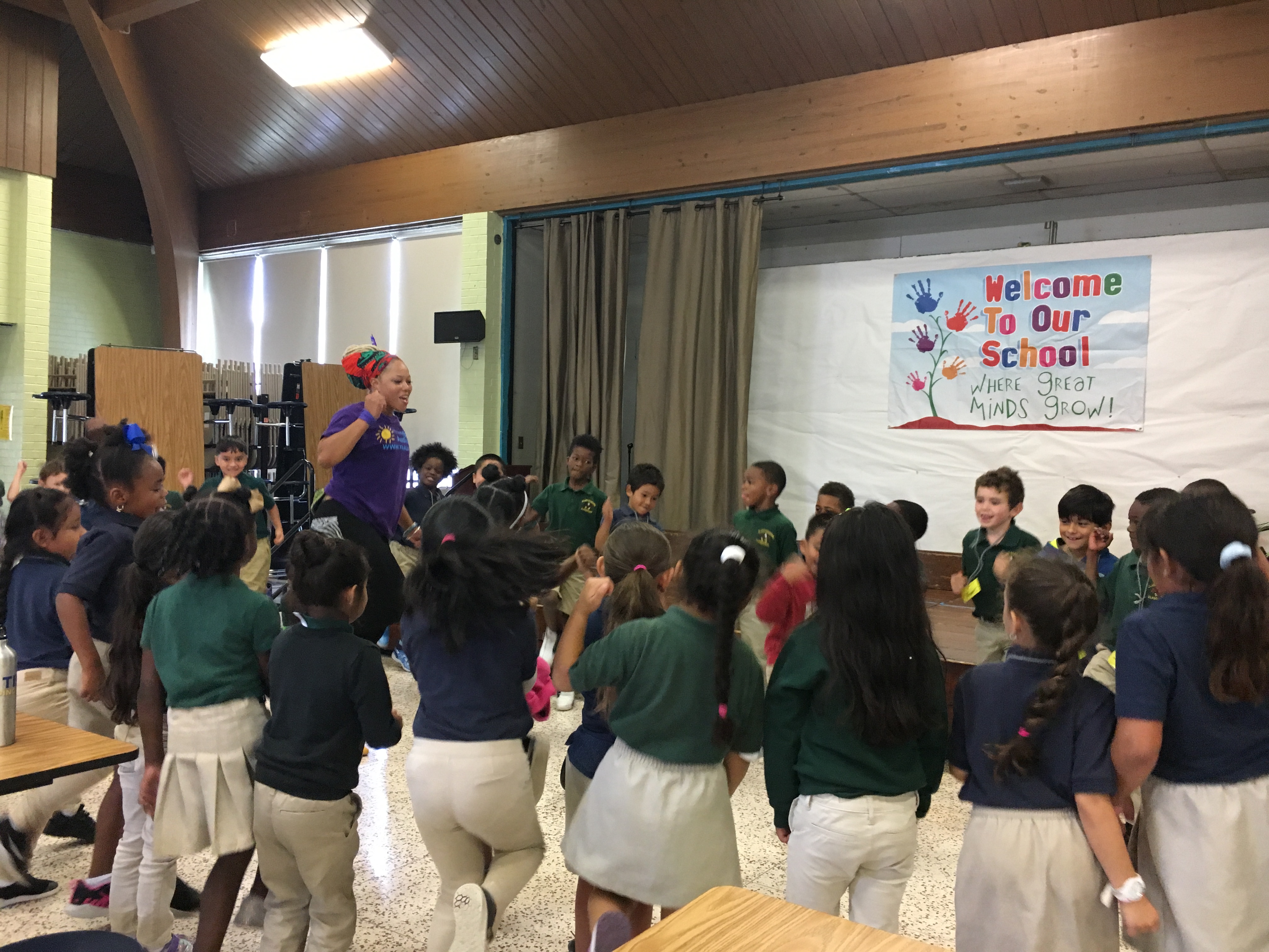 Students surround a teaching artist as she leads an arts education lesson.